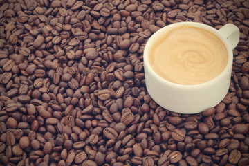 Cup of espresso coffee on roasted coffee beans background