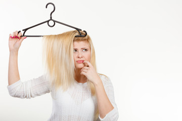 Obraz premium Blonde woman holding hair on clothes hanger