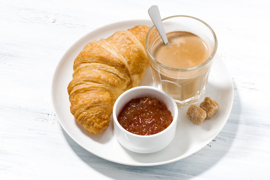 coffee with milk and croissants with jam on white table