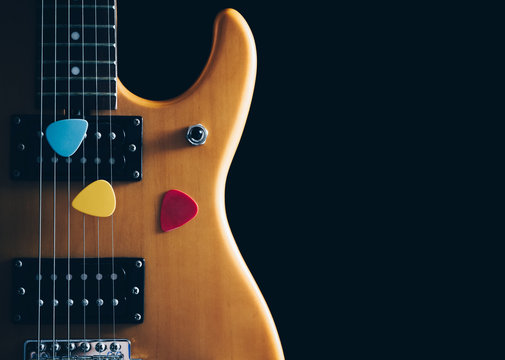 colourful picks on electric guitar, isolated on black