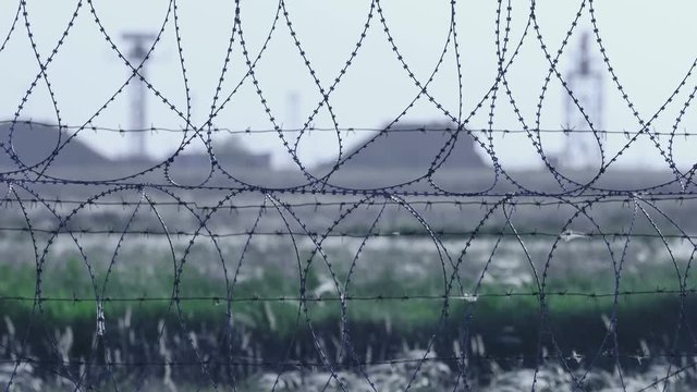 Barbed wire. Selective focus of barbed wire at airport with radar antennas in the background.