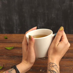 woman holding hot cup of tea