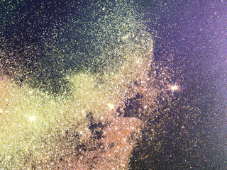 Golden glitter on dark background like a space and a galaxy