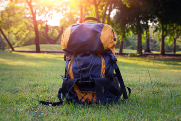 Thermos and backpack outdoors on autumn nature, hiking theme, bag with nature, sunshine.
