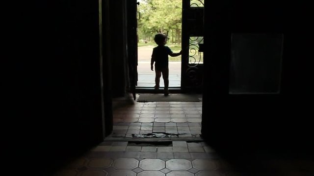 little boy comes out of the door