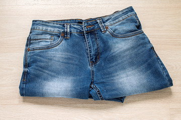 New blue jeans on wooden background