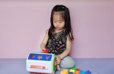 asian kid girl playing colorful plastic toys.