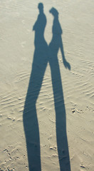 Shadow of man and woman on a sand