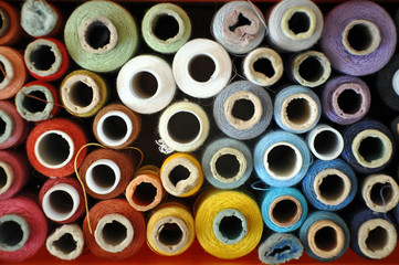 Lots of colorful spools of thread for sewing. Top view, background.