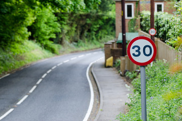 Speed limit sign on side of road in UK