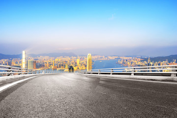 Obraz premium empty road with modern city at sunrise