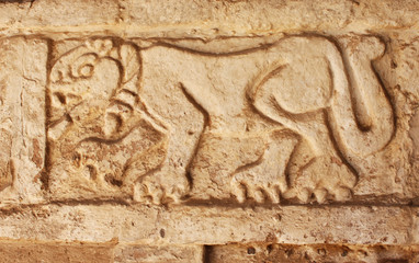 Grunge background with stucco texture and bas-relief carving of  jaguar
