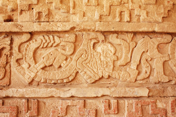 Grunge background with stucco texture and bas-relief carving of  jaguar