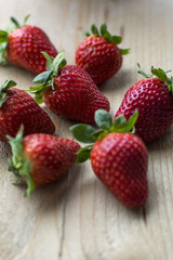 Several big fresh strawberries are on the wooden background