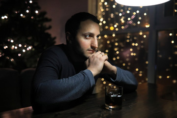 man with glass of whisky in the pub on night