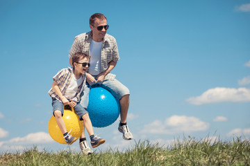 Father and son playing on the field at the day time.