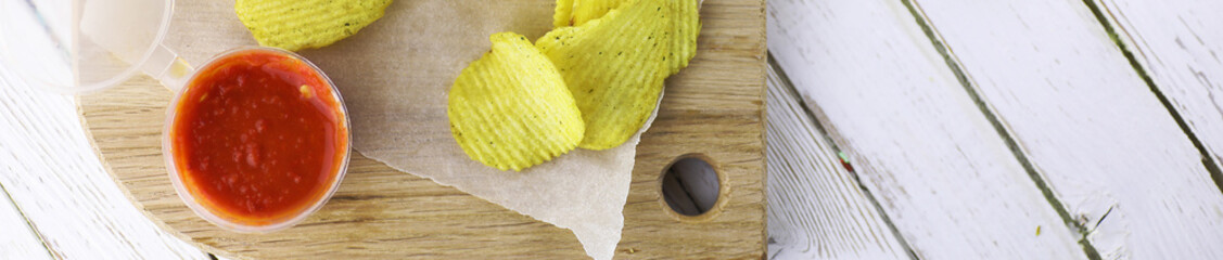 Horizontal bakground of potato chips on a table
