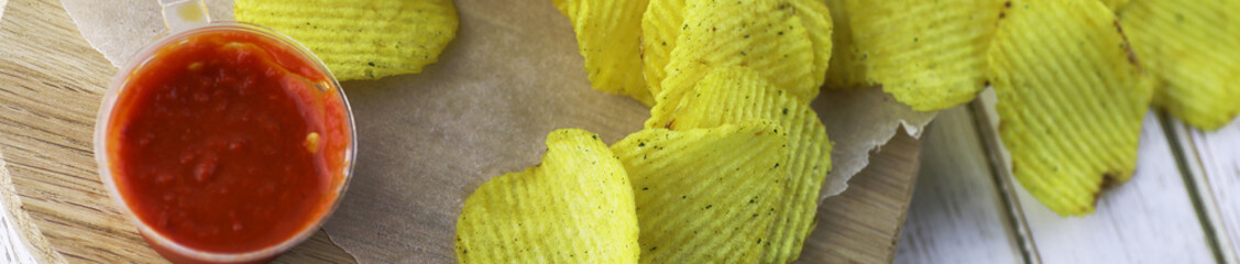 Horizontal bakground of potato chips on a table