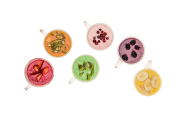 Top view of fresh fruit smoothies in glass cups isolated on white