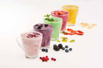 Close-up view of fresh fruit smoothies in glass cups isolated on white