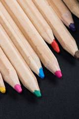 Obraz premium Close-up view of set of wooden color pencils on black