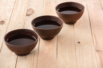 Close-up view of fresh clean water in three bowls on wooden table
