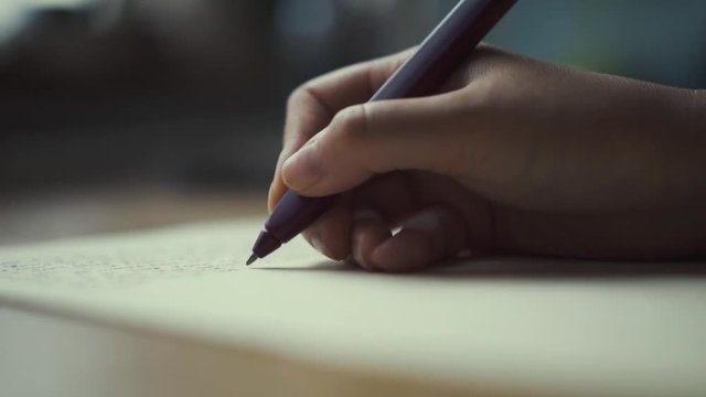 Hands of a woman writing on a piece of paper. Writing love letters.
