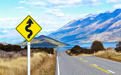 Empty road and traffic sign in landscape view at Lake Wakatipu South Island, New Zealand