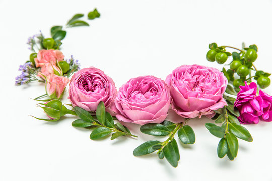 Close-up view of beautiful floral wreath with pink roses isolated on white