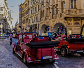 Antique restored cars on the street in "Lesser town" , what leading to the Charles Bridge . The old town district . Prague , Czech Republic .