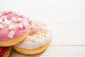Close Up view of three tasty donuts with frosting on the top on wooden table. appetizing chocolate donuts background