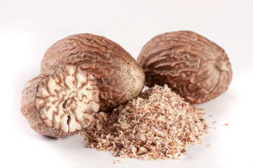 Three nutmeg and powder isolated on white background