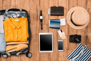 Flat lay of summer vacation things neatly organized on wooden background. Travel concept.
