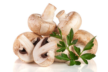 A bunch of champignon mushrooms with leaf parsley isolated on white background