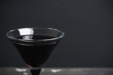 Black martini cocktail on the rustic background. Shallow depth of field.
