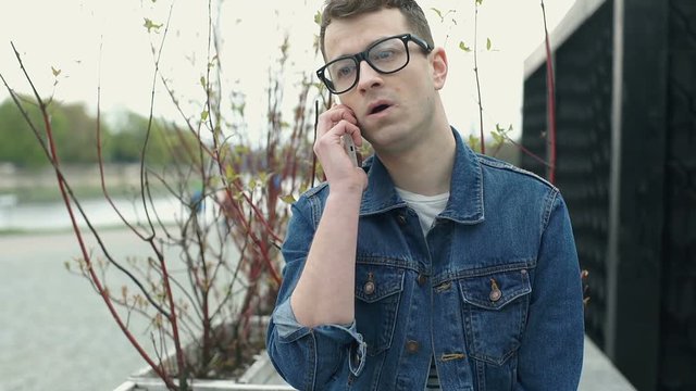 Stylish man receives bad news while talking on cellphone, steadycam shot
