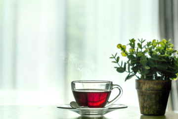 Close up the  warm black tea cup on the wooden table in living room , relax with tea time concept