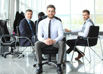Fototapeta premium Happy smart business man with team mates discussing in the background.