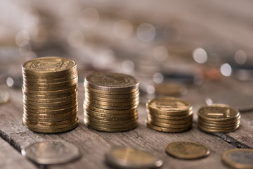 Stacks of coins on wooden tabletop, coins stacked concept