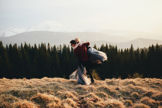 Man Carries Woman In Fancy Dress Over The Hill