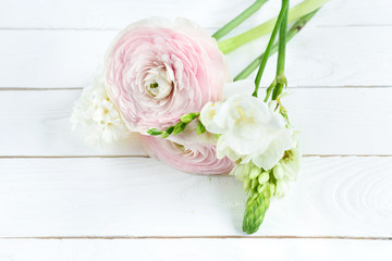 Close-up view of beautiful tender pink and white flowers on wooden table