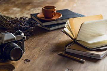 vintage photo camera, and diaries and cup of coffee on wooden tabletop