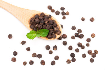 Black peppercorn in a wooden spoon isolated on white background. Top view