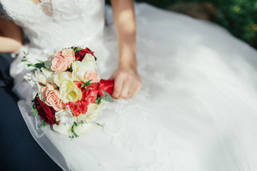 The charming bride keeps a wedding bouquet