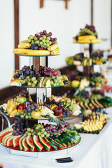 The bananas,watermelons,grapes,peachs and pineapples standing on the plate
