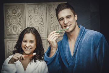 Couple in the bathroom brushing teeth.