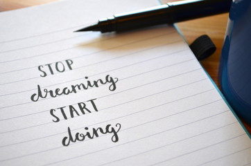 STOP DREAMING START DOING hand lettered motivational quote in notebook
