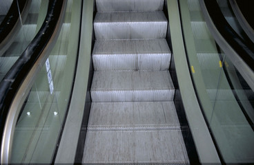 Fototapeta premium A picture taken from the bottom of an escalator that's going up.