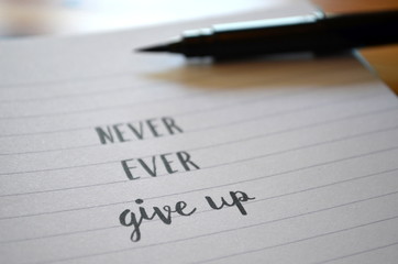 Motivational quote NEVER, EVER GIVE UP hand lettered in notebook