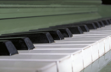 A side view of the keys of a green piano.